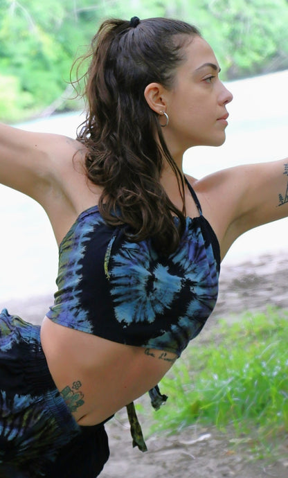 Halter Top with blue swirl tie dye pattern worn by woman in yoga pose. Ties on the back and around the neck. 