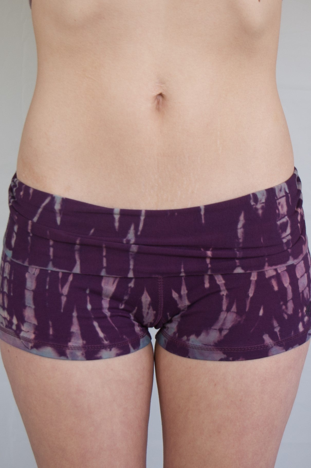 Lotus Tribe Clothing's curve hugging Amethyst tie dye shorts are purple with lavender highlights have a fold over waist are soft and comfortable. Ethically made of 90% cotton 10% spandex