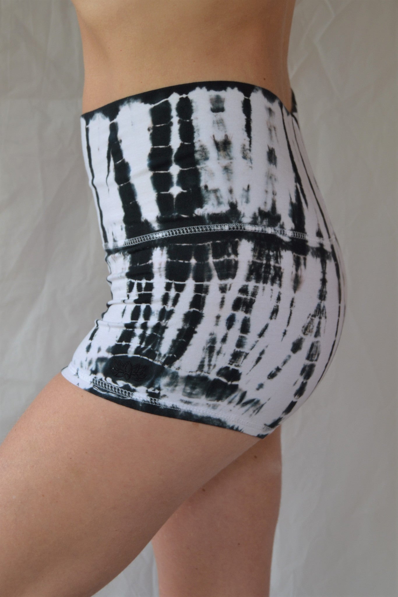 Soft and comfortable crisp white with black tie dyed yoga shorts with fold over waist for adjustable custom fit, can be worn higher waisted, or low on the hips.