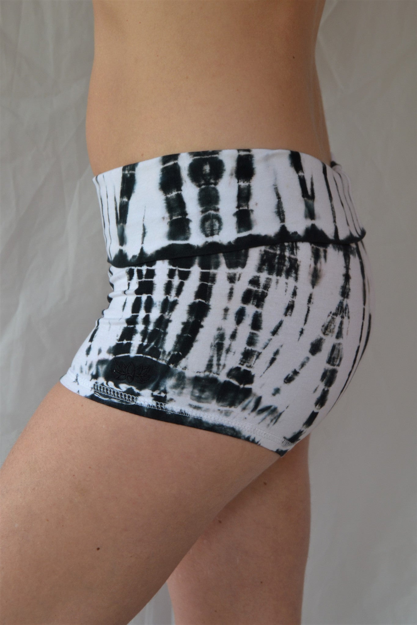 Soft and comfortable crisp white with black tie dyed yoga shorts with fold over waist for adjustable custom fit, can be worn higher waisted, or low on the hips.