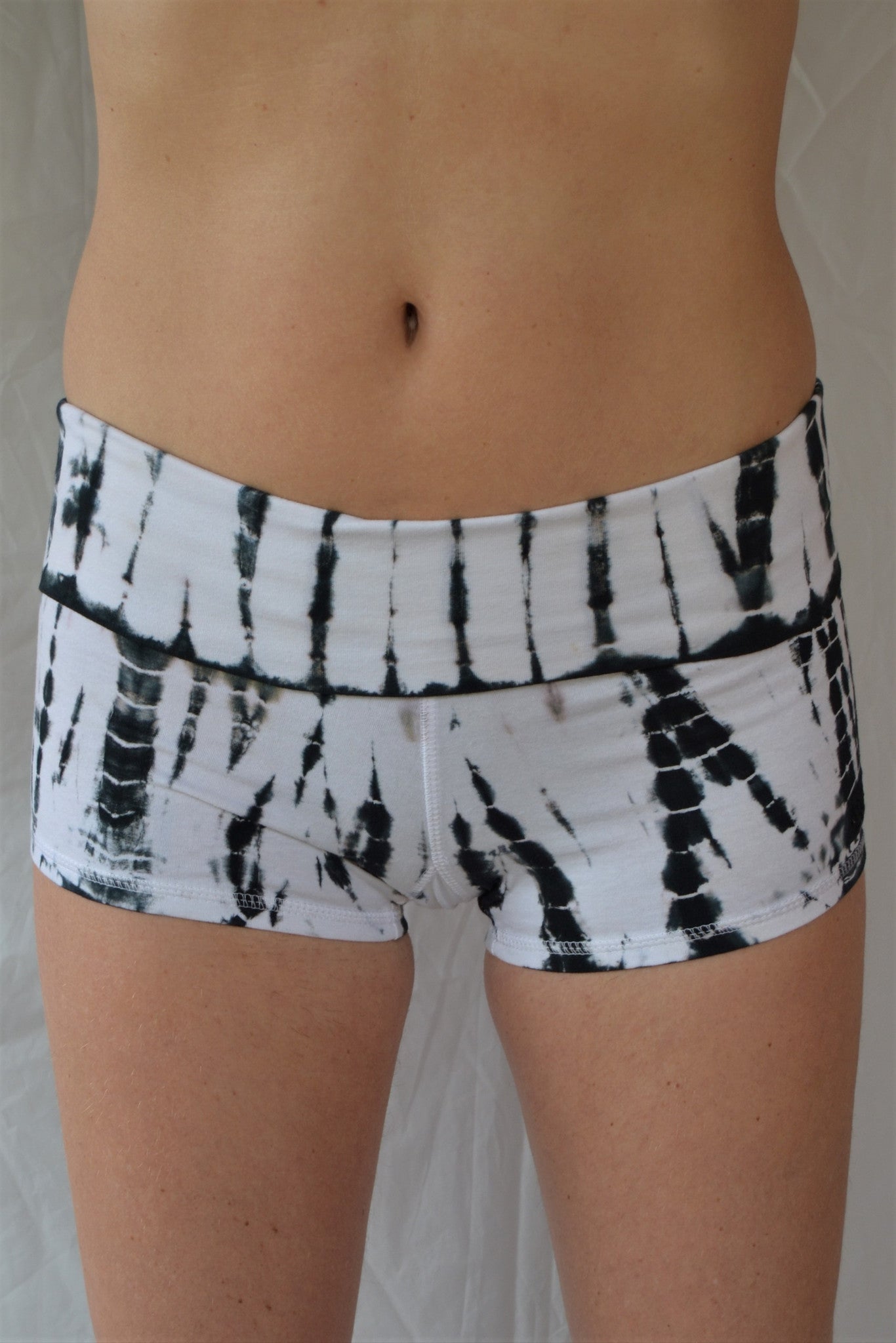 Soft and comfortable crisp white with black tie dyed yoga shorts with fold over waist for adjustable custom fit, can be worn higher waisted, or low on the hips.