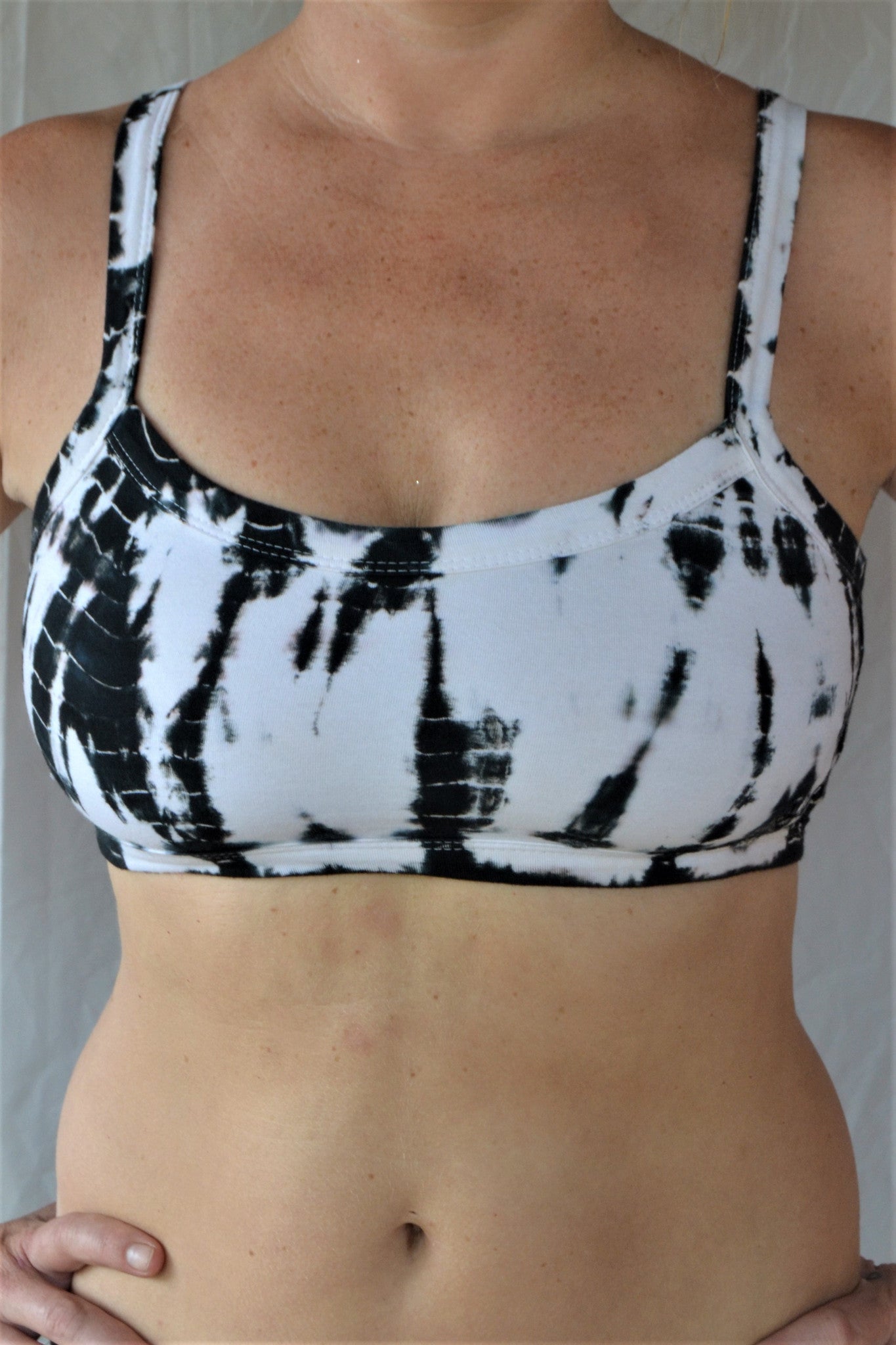 White with black tie dye sportsbra with three horizontal straps across the back. Incredibly comfortable with lighter support. Super soft 90% cotton 10% spandex 