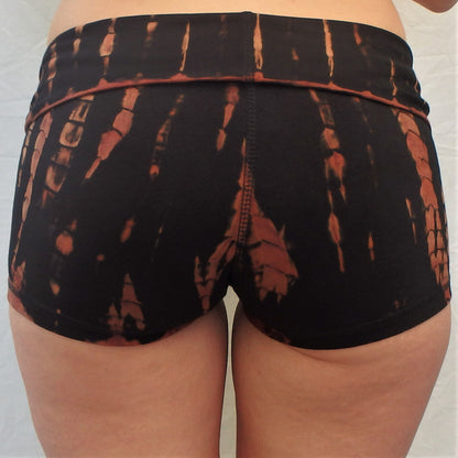 Lotus Tribe Clothing's curve hugging fire tie dyed short shorts are black with burnt orange highlights, have a fold over waist are soft and comfortable ethically made of 90% cotton 10% spandex.