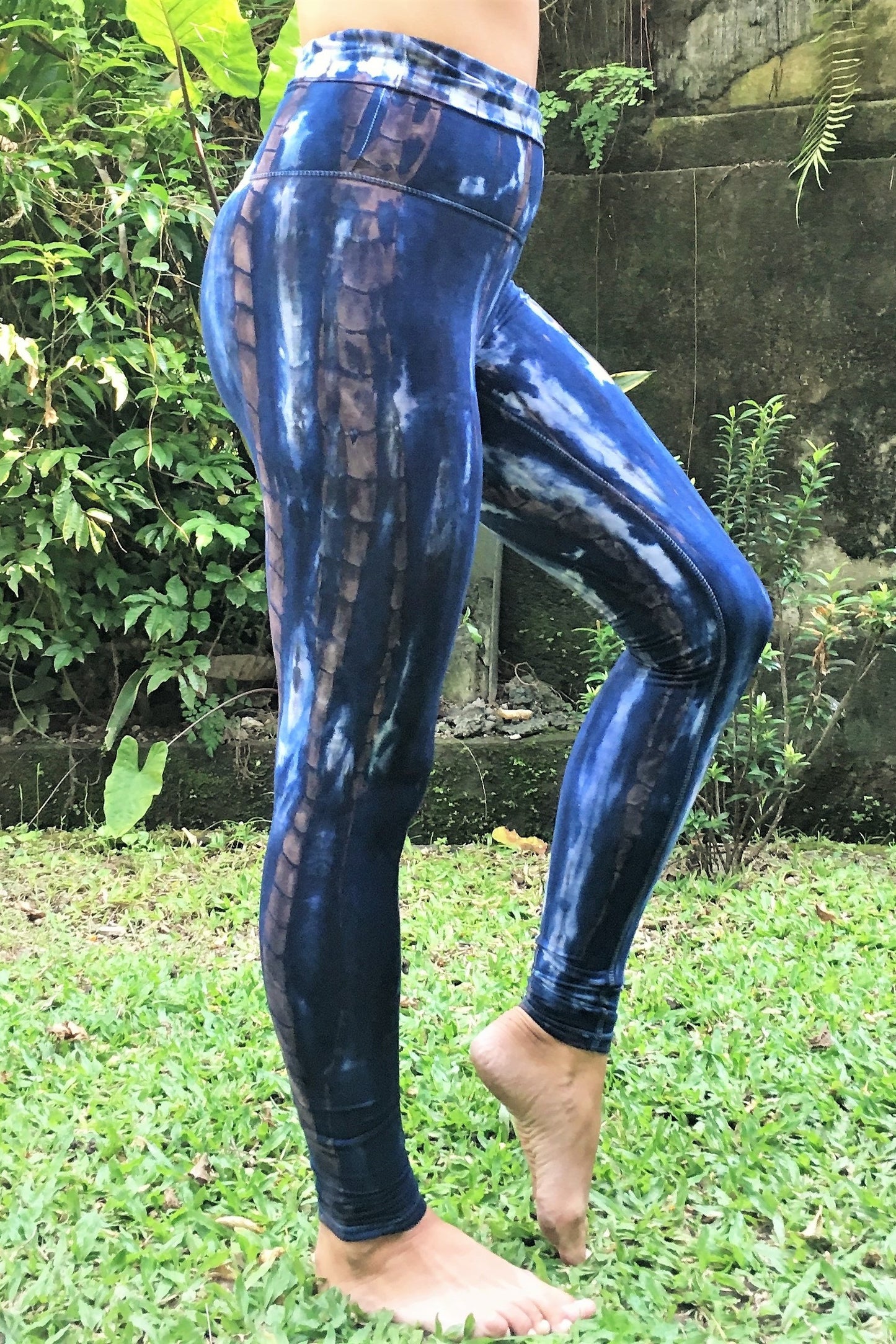 Side view of Organic Yoga Pants in Indigo Earth tie dye, dark blue with brown streaks and white highlights. Made of 90% Organic Cotton with 10% Spandex, extra long length and high waist that can be folded over for custom fit. 