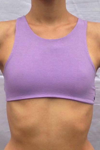 Front view of solid Lavender yoga crop top bra that accentuates the natural beauty of a woman's back with light support and lace up corset back, perfect for festival season.