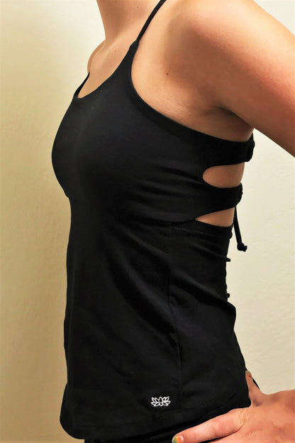 Side view of black Onyx Tie Back Tank has small white lotus flower embroidery on bottom left side. 