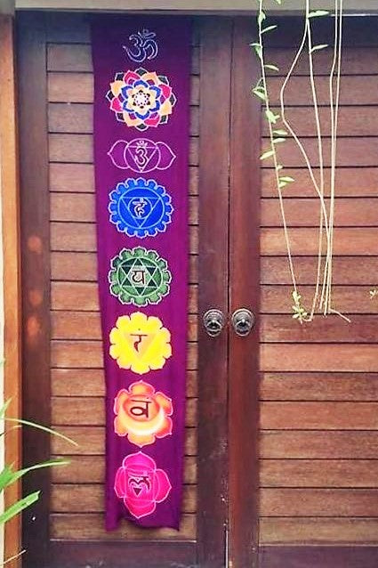 Vertical wall art with Batik 7 Chakra symbols in rainbow of colors on Purple background. Ethically hand made of 100% rayon fabric. Ready to hang. 