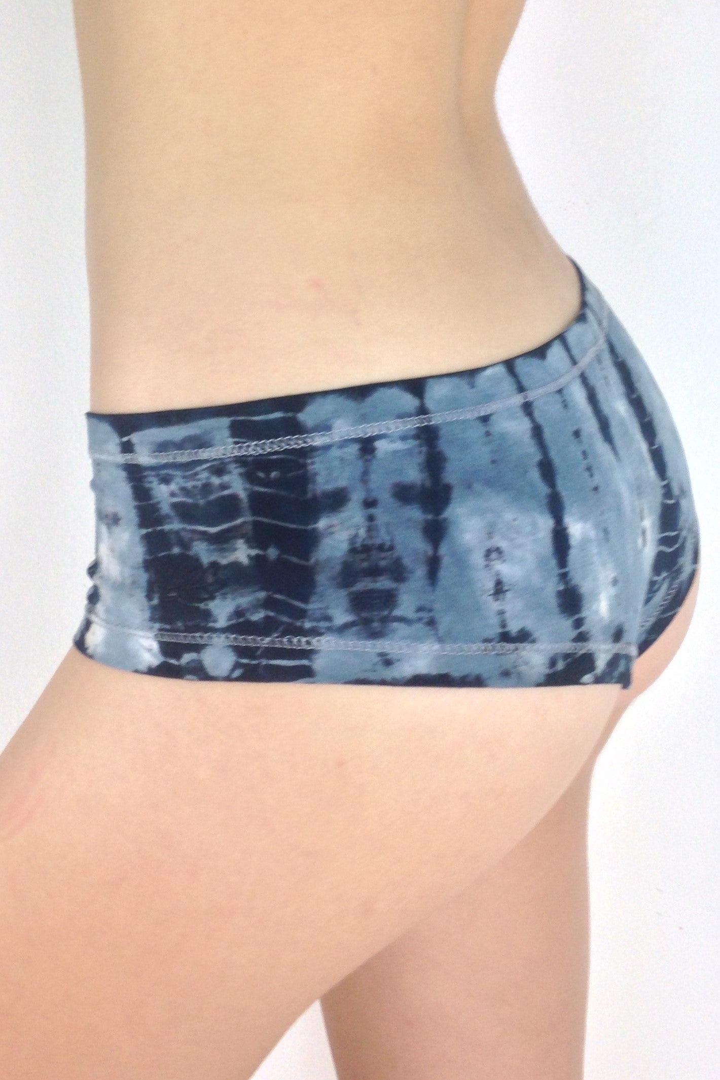 Side view of Sodalite Tie Dye Cheeky Undies, blue grey tie dye with black and white highlights 90% cotton 10% spandex with small lotus flower embroidery detail on left leg