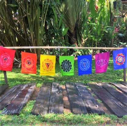 Handmade batik Chakra Flags 7 piece set. Each flag has one chakra in a rainbow of colors. Comes ready to hang on string. Rayon fabric. 